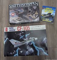 Overview of all three items: sealed Revell Hawker Hurricane kit, Avro Arrow CF-105 kit box, Great Aircraft of WWII book