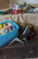 Overall lot showing trunk, charger, blue tote, tools spread out