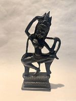 Full view of carved wooden Apsara statue on plinth