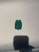 Front view of turquoise-coloured Aztec motif pendant