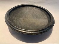 Top view of handmade earthenware grinding bowl showing incised interior texture and raised rim