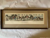 Framed panoramic colour etching showing street scene, entire frame visible