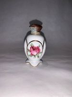 Front view showing floral design, gold trim, copper lid