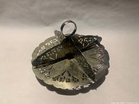Top angled view of silver biscuit tray showing four compartments, pierced decoration, and ring handle