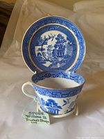Spode Blue Willow bucket-shape teacup in front of matching saucer