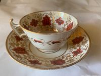 Teacup and saucer showing floral and gold leaf pattern