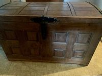 Front and top view of carved wood trunk with metal latch