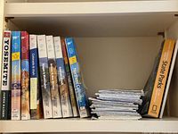 Shelf showing AAA TourBooks, Yosemite guide, Northern California guide, National Geographic State Parks guide, and stacked folded AAA road maps