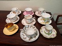 All nine teacup and saucer sets displayed on table