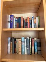 Two bookshelf shelves filled with the vintage hardcover books in the lot