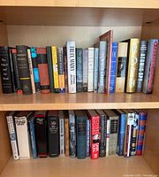 Two shelf rows filled with assorted vintage hardcover and paperback books