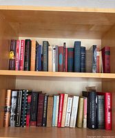 Two shelves filled with assorted hardcover books