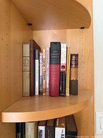 Books standing on corner shelf showing spines