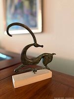 Front left view of bronze ibex statue on marble base