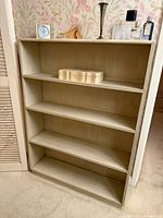 Front view of light wood bookcase with four shelves