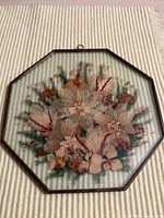 Front view of octagonal pressed flower wall art in metal frame