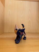 Front angled view of porcelain cat figurine showing facial design and color scheme