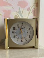 Front view of Seiko gold-tone alarm clock showing full dial and frame