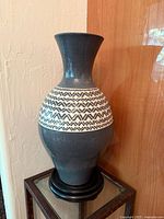 Full view of vase on stand showing overall form and pattern