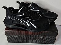 Both sneakers on top of original box showing upper design and branding