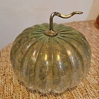 Angled view of crackle glass pumpkin showing stem and ribbed body