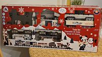 Front of boxed Lionel Holiday Train Set showing locomotive, tender, passenger cars through clear windows