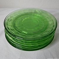 Stack of six green uranium glass saucers
