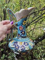 Left side view of hand-painted Hubert Bequet pitcher showing floral relief and handle