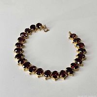 Full view of yellow gold bracelet with garnet stations