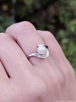 Ring on hand showing overall design and pearl setting
