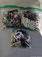 Three ziplock bags filled with assorted costume jewelry