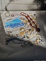 Overall view of assorted necklaces, bracelets, brooches, earrings and ring on tabletop