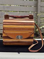Front view of wood slat purse showing clasp and handle