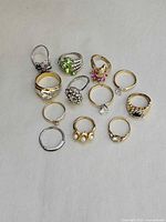 All twelve rings laid out, showing variety of styles and stones