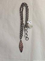 Full view of necklace showing chain, pendant and tags