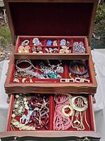 open jewelry box showing trays with assorted jewelry pieces