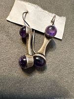 Front view of both sterling earrings showing purple cabochon stones