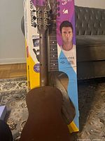 Back of acoustic guitar against original box