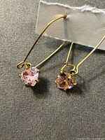 Full view of both gold-tone earrings showing pink heart stones and hook wires
