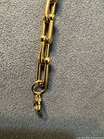 Close-up of bracelet link showing gold-tone finish and ball connector
