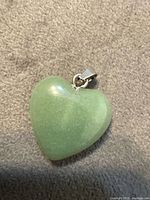front view of green stone heart pendant showing shape and bail
