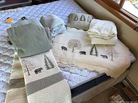 Overall lot on mattress showing quilt, shams, throws, coverlets