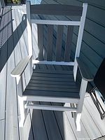 Front view of white and gray poly lumber rocking chair showing full design and materials