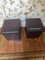 Two dark brown cube ottomans with lids on hardwood floor