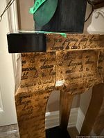 Close view of tabletop corner showing script overlay and black top surface