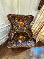 Front view of wingback armchair showing upholstery pattern and wooden frame