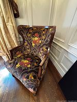 Front view of armchair showing seat, arms, and tapestry upholstery