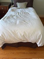 Overall view of twin bed dressed with bedding set