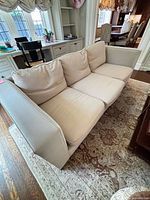 full view of three-seat sofa showing fabric cushions and leather arms