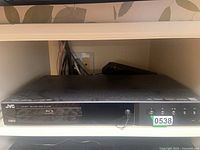 Front view of JVC XV-BP1 Blu-ray Disc Player in shelf